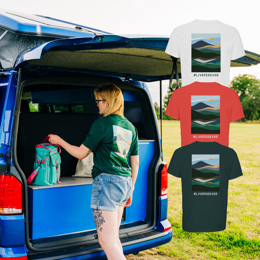 Person loading a blue van with a green backpack, surrounded by t-shirts with mountain designs and '#LIVEPEREFOREVER' text.